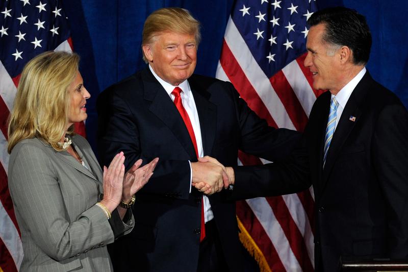 Ann Romney looks on as Donald Trump and Republican presidential candidate, former Massachusetts Gov. Mitt Romney shake hands during a news conference held by Trump to endorse Mitt Romney for president
